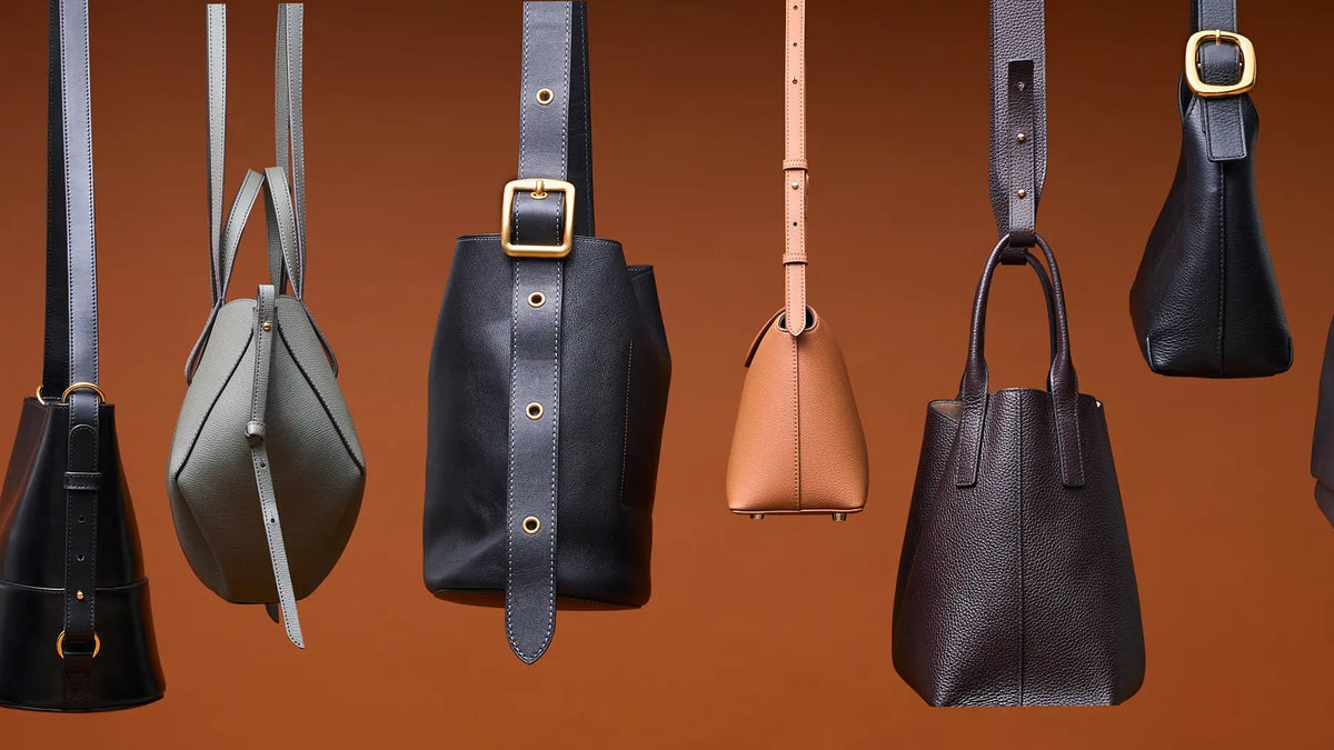 Collection of various leather handbags on a brown background